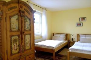 巴哈拉赫Ferienwohnung mit Balkon und Rheinblick的一间带两张床和大型木制橱柜的卧室