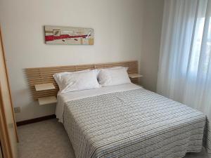 比比翁梅尔酒店的一间卧室配有带条纹被子的床