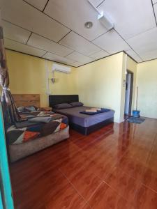 Kampong JuaraRainbow Tioman Cottage的一间设有床铺和沙发的房间