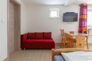 博希尼博尔公寓的客厅配有红色的沙发和桌子