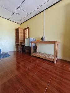 Kampong JuaraRainbow Tioman Cottage的客房铺有木地板,配有桌子。