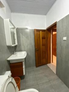 基加利BIZI HOMES的一间带卫生间、水槽和门的浴室