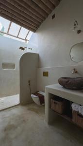 蒙纳The Mudhouse Marayoor的客房内设有带水槽和卫生间的浴室