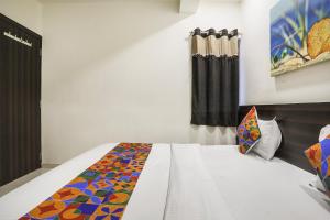 拉杰果德FabHotel SK的一间卧室配有一张带彩色毯子的床
