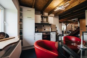 施内沃丁根Ferienwohnung Olaf的厨房配有红色椅子和白色橱柜