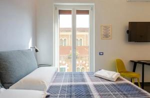 萨莱诺B&B Un Passo Dal Treno Piazza Vittorio Veneto 35的一间卧室设有一张床和一个窗口