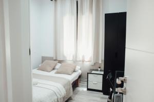巴塞罗那鲁塔弗朗西亚旅馆的一间卧室设有两张床和窗户。