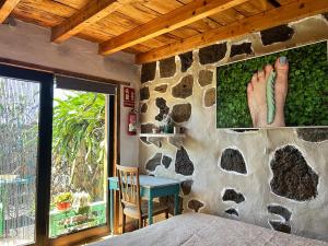 TaibiqueHome2Book Charming Casa Juaclo El Pinar, Terrace的一间卧室设有石墙、一张床和一张桌子