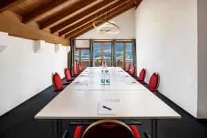 塞利斯贝格贝尔维尤酒店及自然别墅的一间会议室,配有长白桌子和红色椅子