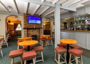 CliftonLowther Park的餐厅设有木桌、椅子和电视。