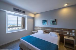 福塔莱萨Oasis Imperial & Fortaleza的一间卧室设有一张大床和大窗户