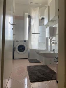 米兰Cadolini Apartment的白色的浴室设有洗衣机和水槽。