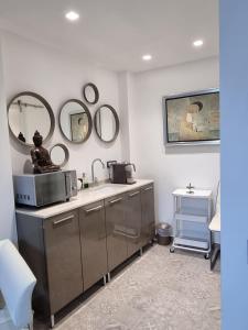 圣雷莫Palms Luxury Suites Sanremo的浴室设有水槽和墙上的镜子