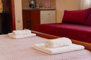 普雷韦扎Apartments Vasileiou Suite 2的酒店客房的两张床上配有2条毛巾