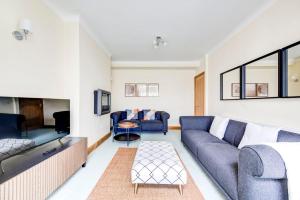 BrentGuestReady - A peaceful stay near the city centre的客厅配有蓝色的沙发和电视