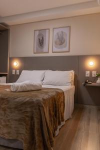 João NeivaAugusta Hotel的一间卧室配有一张大床,床上有毯子