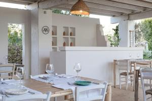 加利波利马赛利亚夫吉酒店的用餐室配有白色的桌子和白色的椅子
