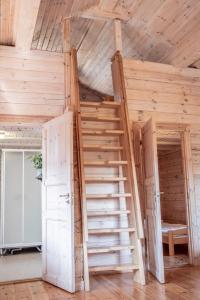 奥尔延Noretjärns Stugby的一张木制双层床,在房间内配有梯子