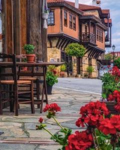 阿尔奈阿Aristotelous Alexandrou Historic Inn的大楼前的桌子、椅子和鲜花