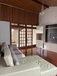 布鲁马迪纽Pousada Verde Villas的一间铺有木地板并配有白色沙发的大客厅
