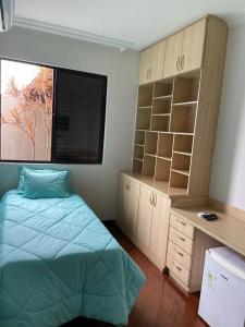 布鲁马迪纽Pousada Verde Villas的一间卧室配有一张床、一张书桌和一个窗户。