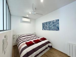 滨海卡瓦莱尔Appartement 1ch avec terrasse et jardinet à 400m de la plage的卧室配有一张床,墙上挂有绘画作品