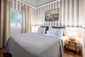 韦策Schloss Hertefeld & Hertefeldhof的一间卧室配有一张蓝色和白色条纹的大床