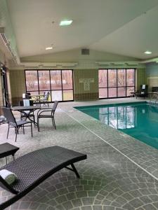 亚克朗Holiday Inn Express - Akron NW - Fairlawn, an IHG Hotel的大楼内带桌椅的游泳池