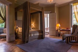 圣帕泰讷圣帕特纳城堡酒店的一间卧室配有一张天蓬床和一张书桌