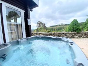 BalnaldKaoglen-GrandSuite-Hot Tub-Pitlochry-Dunkeld-Pet Friendly的房屋后院的热水浴池