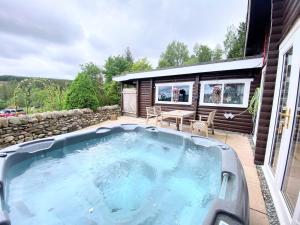 BalnaldKaoglen-GrandSuite-Hot Tub-Pitlochry-Dunkeld-Pet Friendly的房屋庭院的热水浴池