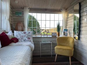 波特劳伊斯Adorable Cabin in the Countryside的卧室配有床、椅子和窗户。