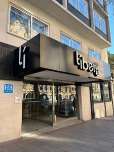 马德里Líbere Madrid Chamberí的建筑前有标志的商店