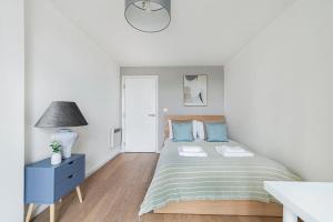 伦敦The Lambeth Apartment的白色卧室配有床和蓝色床头柜