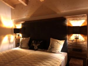 克里姆尔Filzstein Resort Chalet - Zillertal Arena, Hohe Tauern, Salzburgerland, Krimml, Hochkrimml的一间卧室配有一张带木制床头板的床
