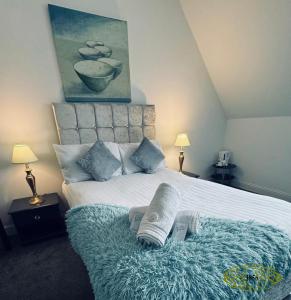 KirnRoyal Marine Hotel Dunoon的一间卧室配有一张带毯子和两盏灯的床。