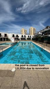 美洲海滩Las Americas Bungamar apartment的游泳池的标志为:游泳池从