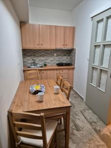 波罗斯多洛辛诺斯公寓的厨房配有木桌和2杯