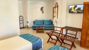 阿约拉港加拉帕戈斯套房住宿加早餐旅馆的客厅配有床和蓝色沙发