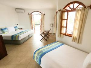 阿约拉港加拉帕戈斯套房住宿加早餐旅馆的一间卧室配有两张床和椅子