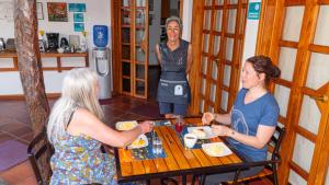 阿约拉港加拉帕戈斯套房住宿加早餐旅馆的三个女人坐在餐桌上吃着食物