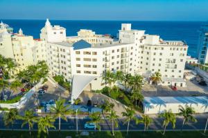 坎昆Cyan Cancun Resort & Spa的一座棕榈树和海洋的白色大建筑