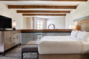 斯科茨JW万豪斯科特斯德驼峰山度假酒店的一间卧室配有一张大床和电视