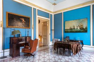 巴勒莫Cathedral View Apartments的一间拥有蓝色墙壁、一张桌子和一把椅子的房间