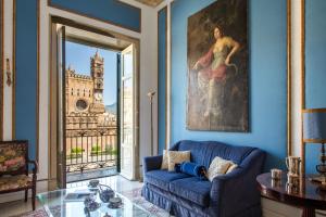 巴勒莫Cathedral View Apartments的客厅设有蓝色的沙发和大窗户