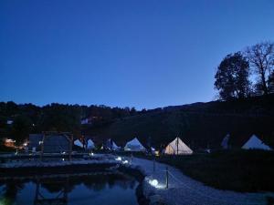 拉多夫吉卡White Tent Mountain View in camp Garden Park的一群帐篷和池塘
