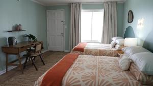 卡罗来纳比奇The Savannah Inn的酒店客房配有两张床、一张书桌和一张书桌。