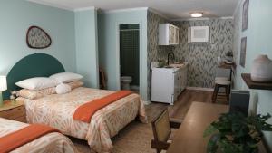 卡罗来纳比奇The Savannah Inn的一间带两张床和一张桌子的卧室以及一间厨房