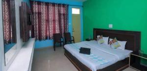 达兰萨拉Mcleodganj Diaries Homestay的一间卧室设有一张大床和绿色的墙壁