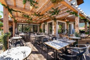 杜萨尔L'Arcalod Lac d'Annecy - Hôtel Restaurant & Spa的餐厅设有木凉棚下的桌椅